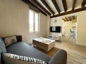 a living room with a couch and a table at L'Eure Tranquille in Chartres