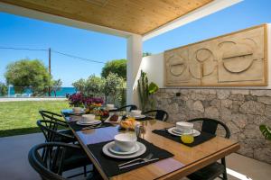 une table en bois avec des chaises noires et une salle à manger dans l'établissement Ocean Pearl Sea View, à Faliraki