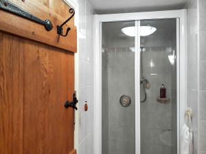 a bathroom with a shower with a glass door at Rose Cottage in Grinton