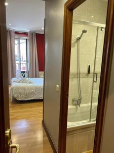 łazienka z prysznicem oraz sypialnia z łóżkiem w obiekcie Hostal New Dream Madrid w Madrycie
