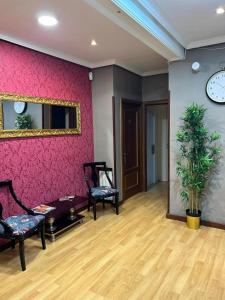 a room with a pink wall with chairs and a mirror at Hostal New Dream Madrid in Madrid