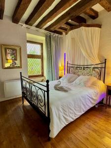 een slaapkamer met een groot bed met witte lakens bij MEUBLE PANORAMIQUE 2 à 6 PERSONNES AU CHÂTEAU DE JALLANGES in Vernou-sur-Brenne