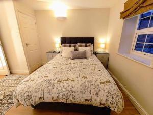 a bedroom with a large bed and two windows at Cosy Central Modern Apartment in Nantwich