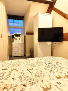 a bedroom with a bed with a tv on the wall at Cosy Central Modern Apartment in Nantwich