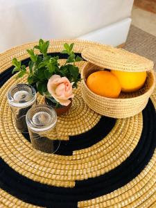 a wicker tray with a bowl of fruit and a lemon at Riad Bamaga in Marrakech