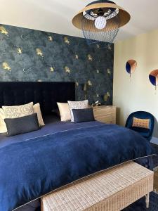 a bedroom with a large bed with a blue blanket at Villa Eulalie B&B Guest House nestled in the Champagne area in Bligny