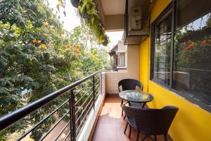 a balcony with two chairs and a glass table at Luho 306 in Bangalore
