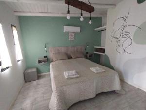 1 dormitorio con cama y pared verde en Sierras Alojamiento en Mina Clavero