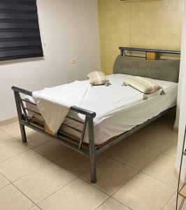 a bed with white sheets and pillows in a room at סוויטה במושב פסטורלי רומנטי ושקט in Gannot Hadar