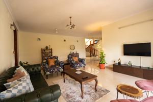 班加羅爾的住宿－Luho 306，客厅配有家具和平面电视。