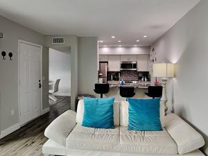 a living room with a white couch with blue pillows at Madeira Beach Yacht Club 247g in St Pete Beach