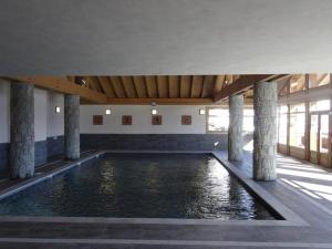 a swimming pool with pillars in a building at Appartement Villard-sur-Doron, 4 pièces, 7 personnes - FR-1-594-53 in Villard-sur-Doron