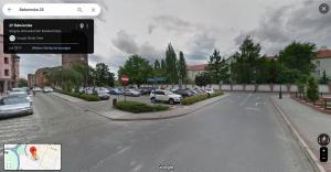une rue de la ville avec des voitures garées dans un parking dans l'établissement City Single Wohnung, à Głogów
