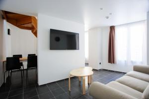 A television and/or entertainment centre at Hôtel & Appartements Monsigny