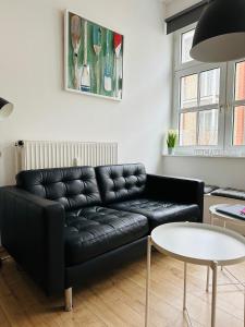 un divano in pelle nera in soggiorno con tavolo di Nordseekrabbe a Norderney