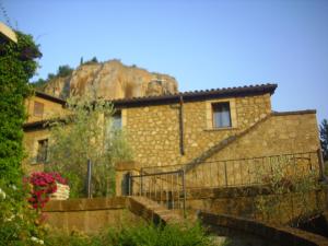 une maison en pierre avec une montagne en arrière-plan dans l'établissement Chiara e Benedetta Villa degli Ulivi, à Orvieto