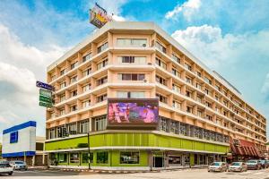 een groot gebouw met een reclamebord erop bij OYO 441 Grand Thara Hotel in Suratthani