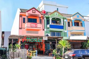 a brightly colored building with a car parked in front at OYO 586 I Hostel in Phuket
