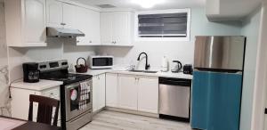 a kitchen with white cabinets and a blue refrigerator at 2 Bedroom Luxury Apartment in Guelph
