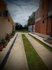 an empty sidewalk next to a building with plants at Sierras Alojamiento in Mina Clavero