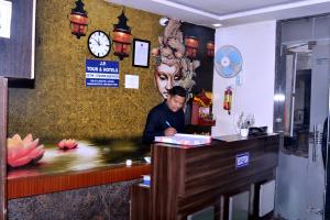 新德里Hotel Aero Indus Near Airport的站在房间柜台上的人