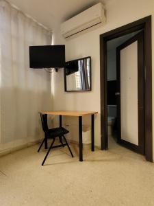 uma mesa com uma cadeira e um espelho num quarto em Aparta Hotel Drake Piantini em Santo Domingo