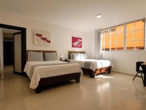 um quarto com 2 camas e uma janela em Aparta Hotel Drake Piantini em Santo Domingo