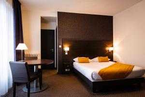 a hotel room with a bed and a table at Hotel Astrid Caen centre in Caen