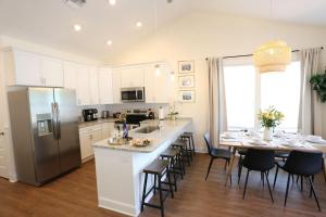 a kitchen with a large island and a table with chairs at The Champion's Suite Newly Built Upscale Central in Gainesville