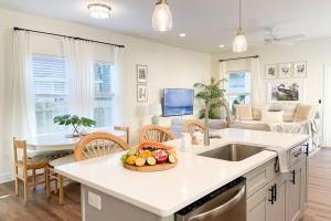 a kitchen and living room with a bowl of fruit on a counter at The Floridian Newly Built Dreamhome Central in Gainesville