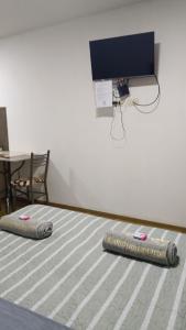 Habitación con colchón y TV en la pared. en céntrico y acogedor apartamento en el Prado, en Cochabamba