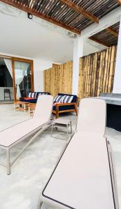 un grupo de sillas y mesas en una habitación en Casa GAIA - Punta Sal en Canoas De Punta Sal