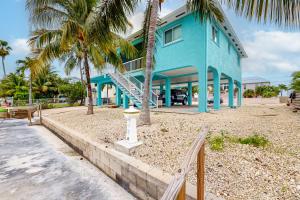 a blue house with palm trees in front of it at Endless Summerland in Summerland Key