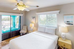 a bedroom with a white bed and a window at Endless Summerland in Summerland Key