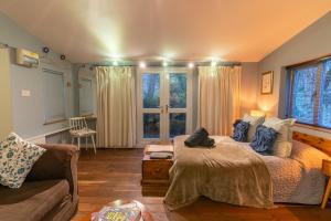 1 dormitorio con cama, sofá y ventana en Somerset Lodge, a secret hideaway, en Bath