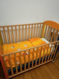 drewniane łóżeczko z żółtym kocem w obiekcie Gloriapartment w mieście Civitavecchia +6 zdjęć