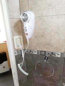 um secador de cabelo está ligado a uma parede na casa de banho em PH tipo casa con Patio - Palermo Hollywood - A cuadras de Santa Fe y Juan B Justo em Buenos Aires