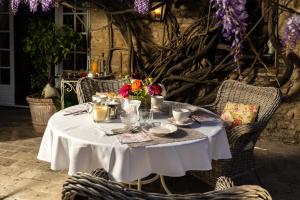 een tafel met een witte tafeldoek en bloemen erop bij Le Clos de Lucie in Lagnes