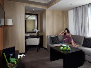 a woman sitting on a couch in a living room at Villa Blanca Urban Hotel in Casablanca