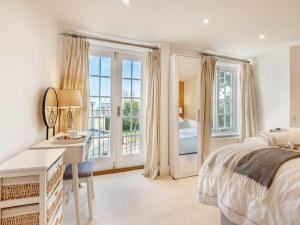 a bedroom with a bed and a desk and a bedroom with a view at Kings Lea in Lymington