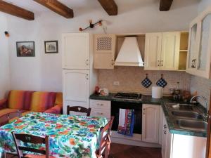 eine Küche mit weißen Schränken und einem Tisch mit Tischtuch in der Unterkunft Ground floor apartment with pool view Gazebo in Pievescola