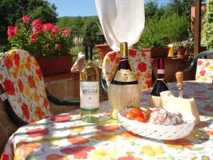 einen Tisch mit zwei Flaschen Wein und einer Schale Obst in der Unterkunft Ground floor apartment with pool view Gazebo in Pievescola
