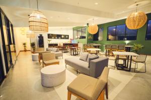 un vestíbulo con sofás y mesas y un restaurante en Ocotea Boutique Hotel, en Monteverde