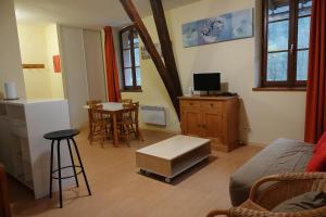- un salon avec un canapé et une table avec des chaises dans l'établissement AppT2 Grand-Hôtel: Nature, Randos & Thermes (cure), à Aulus-les-Bains