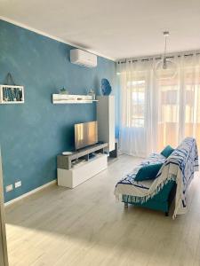 a bedroom with a bed and a blue wall at Appartamento Tizzy in La Maddalena