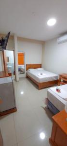 1 dormitorio con 2 camas y TV de pantalla plana en Hotel Moore Iquitos, en Iquitos