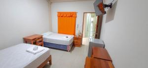 a small room with two beds and a table at Hotel Moore Iquitos in Iquitos