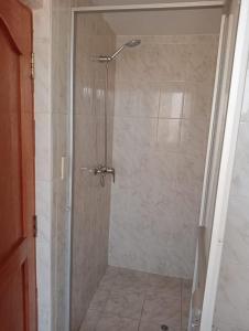 a shower with a glass door in a bathroom at Posada de Mama in Cusco