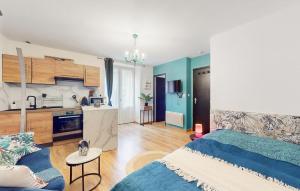 1 Schlafzimmer mit einem blauen Bett und einer Küche in der Unterkunft Cozy Apartment In Marvejols With Kitchen in Marvejols
