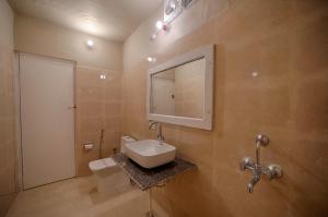 La salle de bains est pourvue d'un lavabo, de toilettes et d'un miroir. dans l'établissement Tiger Machan, à Sawai Madhopur